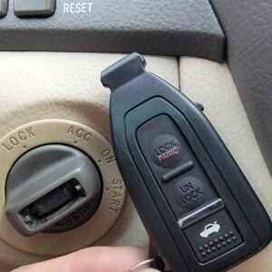 Toyota/Lexus smart key fob near ignition switch showing lock/unlock and panic buttons – immobilizer programming