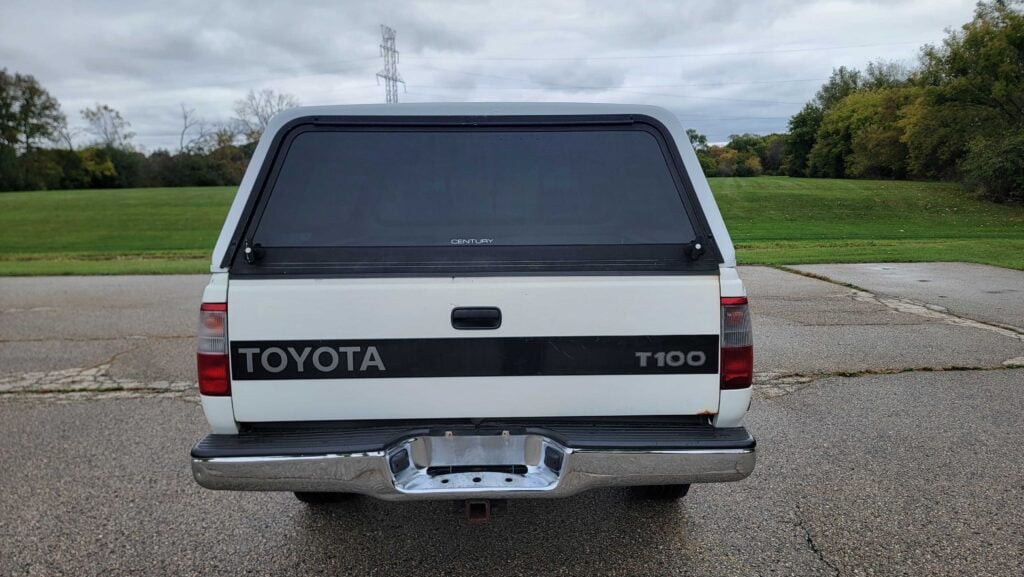 Rear exterior view of 1998 Toyota T100 DX 4x4 showing tailgate and topper