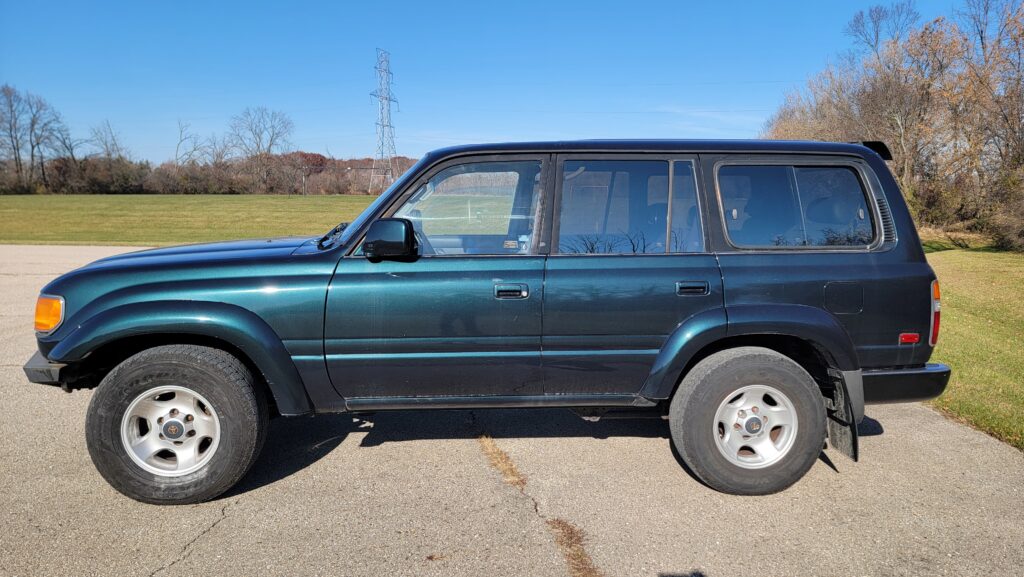 Driver side exterior view of 1994 Toyota Land Cruiser green triple locked Tanin JDM