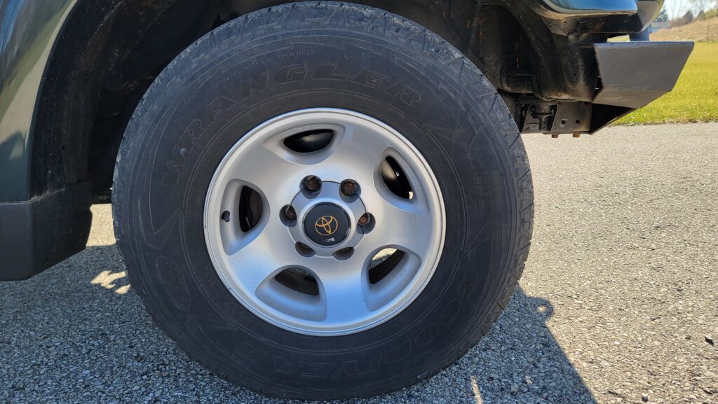 Front wheel and tire of 1994 Toyota Land Cruiser green triple locked