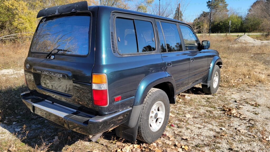 Passenger rear exterior view of 1994 Toyota Land Cruiser green triple locked Tanin JDM