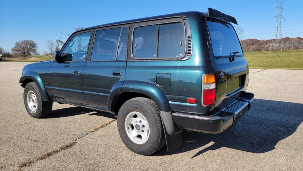Rear driver exterior view of 1994 Toyota Land Cruiser green triple locked Tanin JDM