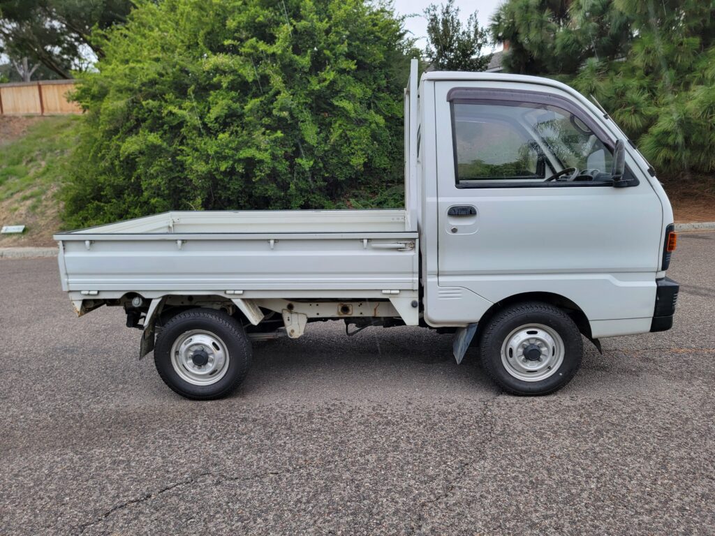 Driver-side profile with dump bed lowered on Minicab