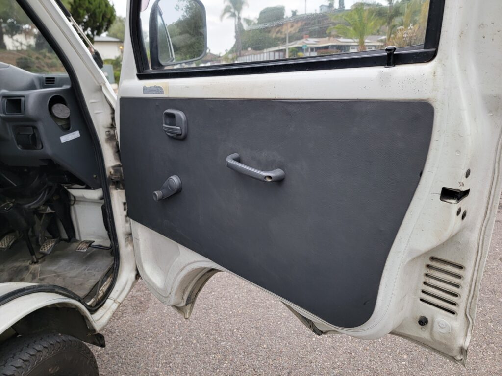 Driver-side interior door panel of 1993 Mitsubishi Minicab kei truck