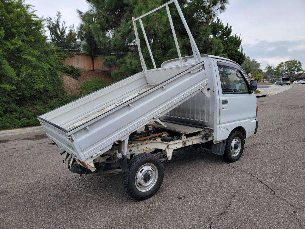 Rear driver-side angle showing dump bed on Mitsubishi Minicab