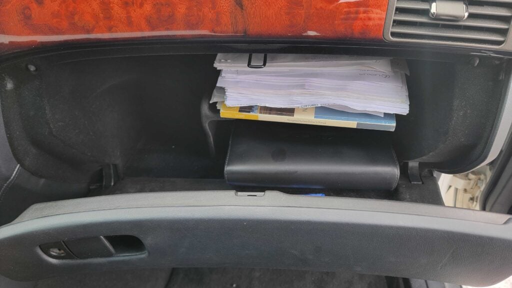Open glovebox showing documents and manuals